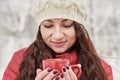 Woman Drinks Hot Tea or Coffee From Cup at Cozy Snowy House Garden on Winter Morning. Beautiful Girl Enjoying Winter Outdoors with Royalty Free Stock Photo