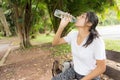 Woman drinks water from bottle in the park Royalty Free Stock Photo