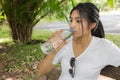 Woman drinks water from bottle in the park Royalty Free Stock Photo