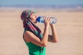 Woman drinks water in the desert of Egypt. Hot weather concept