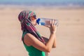 Woman drinks water in the desert of Egypt. Hot weather concept