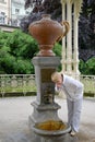 The woman drinks water from a mineral source Royalty Free Stock Photo