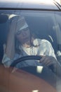 Woman driver being hot during heat wave in car, suffering from hot weather wipes sweat from forehead