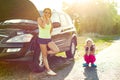 Woman driver with child on country road, near broken car. Royalty Free Stock Photo