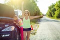 Woman driver with a child on a country road, near a broken car. Royalty Free Stock Photo