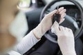 Woman driver with face mask wearing protective gloves and cleaning car key with wet wipe Royalty Free Stock Photo