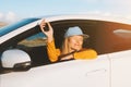 Woman driver in a new car showing keys in open window. Girl buying auto. Road trip travel vacations Royalty Free Stock Photo