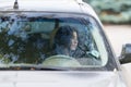 Woman driver sitting waiting in her car.