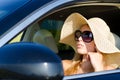 Woman driver in sunhat and sunglasses