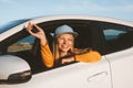 Woman driver traveling in a car showing keys open window. Road trip with rental automobile vacations Royalty Free Stock Photo