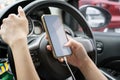 Woman driver using a smartphone in car