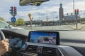 Woman drives electric car BMW IX3 using navigation monitor through streets of Stockholm. Sweden.