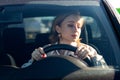 Woman drives her car for the first time, tries to avoid a car accident, is very nervous and scared, worries, clings tightly to the Royalty Free Stock Photo