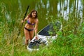 A woman drives on the Sup Board through a narrow canal surrounded by dense grass. Active weekend vacations wild nature outdoor. A Royalty Free Stock Photo