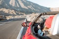 Woman driving convertible car on the desert road