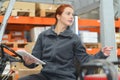 Woman driving fork lift truck in warehouse Royalty Free Stock Photo