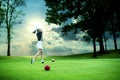 Woman driving golf ball on green golf course Royalty Free Stock Photo