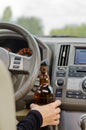 Woman driving holding a bottle of alcohol Royalty Free Stock Photo