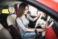 Woman driving new and modern car and turn button on dashboard panel in car