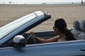 Woman driving by the side of the ocean beach