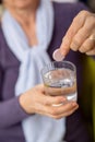 Woman dropping an effervescent antacid in a glass of water Royalty Free Stock Photo