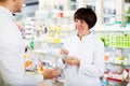 Woman druggist wearing white coat