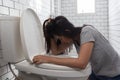 Woman drunk hangover puke in toilet bowl. Female have abdominal pain, nausea, dizziness, nausea, vomit due to food poisoning Royalty Free Stock Photo