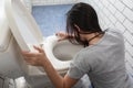Woman drunk hangover puke in toilet bowl. Female have abdominal pain, nausea, dizziness, nausea, vomit due to food poisoning Royalty Free Stock Photo