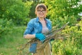 Woman with dry branches of blackcurrant bushes, pruning shears in garden Royalty Free Stock Photo