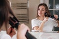 Woman drying her hair, styling in the bathroom near mirror Royalty Free Stock Photo