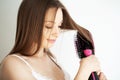 Woman drying long brown hair with blow dryer and round brush Royalty Free Stock Photo