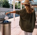 Woman dumping mask into bin on station