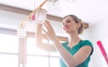 Woman dusting a lamp during spring cleaning