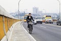 Woman on an e-bike with mout cap, Guangzhou, China