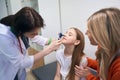 Woman ear, nose and throat specialist using otoscope with light to check nose