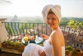 Woman in early morning having breakfast on balcony overlooking city Royalty Free Stock Photo