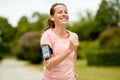 Woman with earphones add armband jogging at park