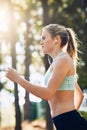 Woman with earphones, running in forest and fitness with music, listening for motivation on run in park. Female runner Royalty Free Stock Photo