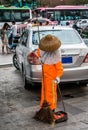 Woman in Eastern dress, sweeping the street.