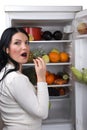 Woman eat a berry grape from fridge Royalty Free Stock Photo