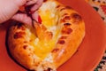 Woman is eating adjarian khachapuri with hands, crushing egg yolk. Royalty Free Stock Photo