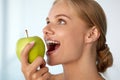 Woman Eating Apple. Beautiful Girl With White Teeth Biting Apple Royalty Free Stock Photo