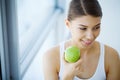 Woman Eating Apple. Beautiful Girl With White Teeth Biting Apple Royalty Free Stock Photo