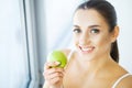 Woman Eating Apple. Beautiful Girl With White Teeth Biting Apple Royalty Free Stock Photo