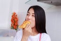 Woman eating a bread in kichen room