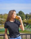 Woman eating burger and fries smiling. Beautiful caucasian female model eating a hamburger with hands Royalty Free Stock Photo