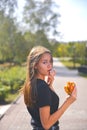 Woman eating burger and fries smiling. Beautiful caucasian female model eating a hamburger with hands Royalty Free Stock Photo