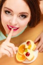 Woman eating cake showing quiet sign. Gluttony.