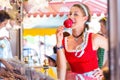 Woman eating candy apple at Oktoberfest or Dult