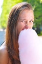 Woman is eating candyfloss in park